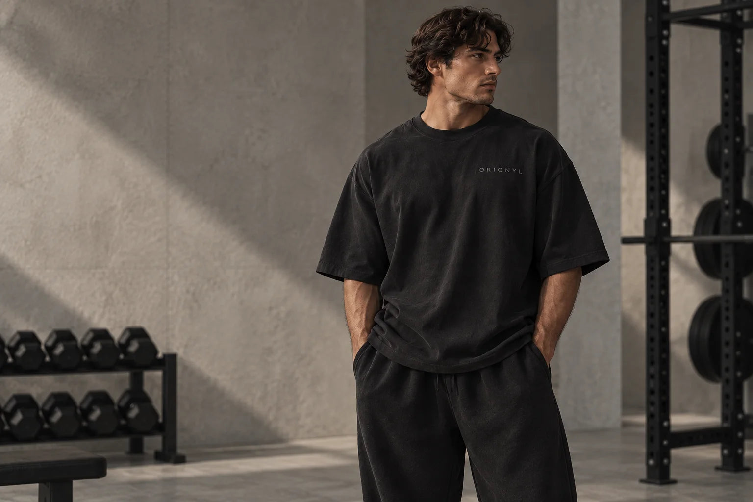 ORIGNYL campaign concept: oversized black essentials in a gray stone gym